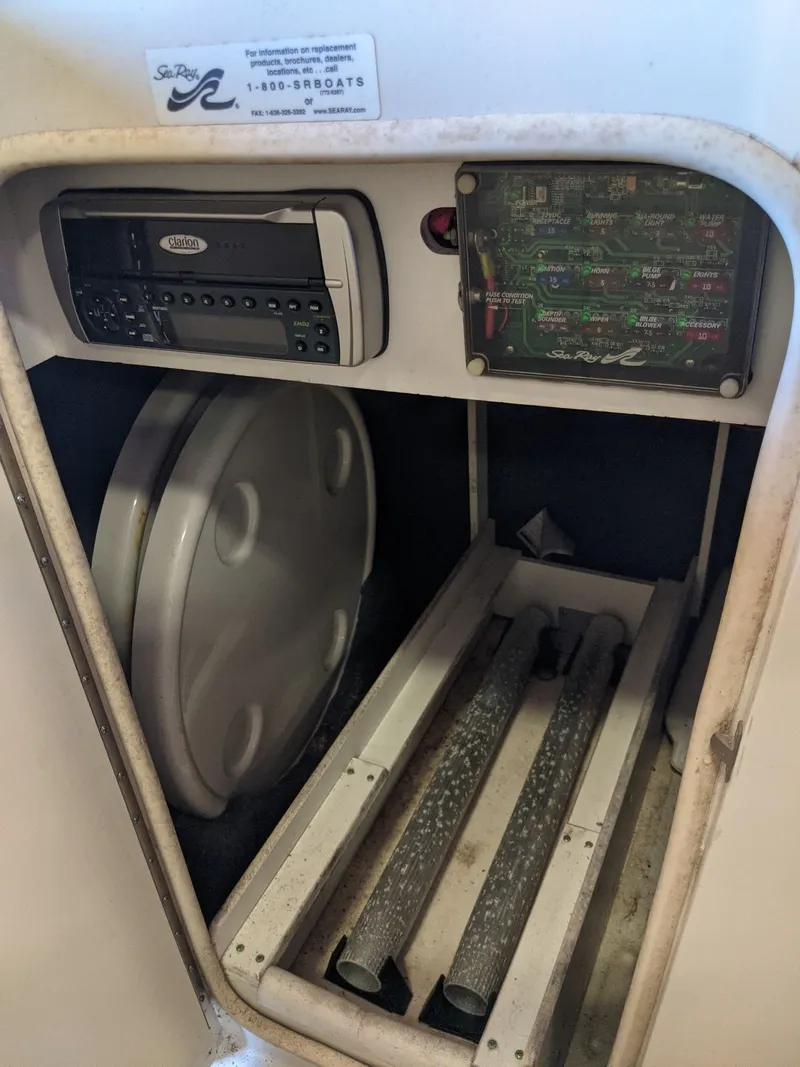 Slide: The Image of A view inside a storage compartment of a 2002 Sea Ray 220 Sundeck boat with electronics. - 16