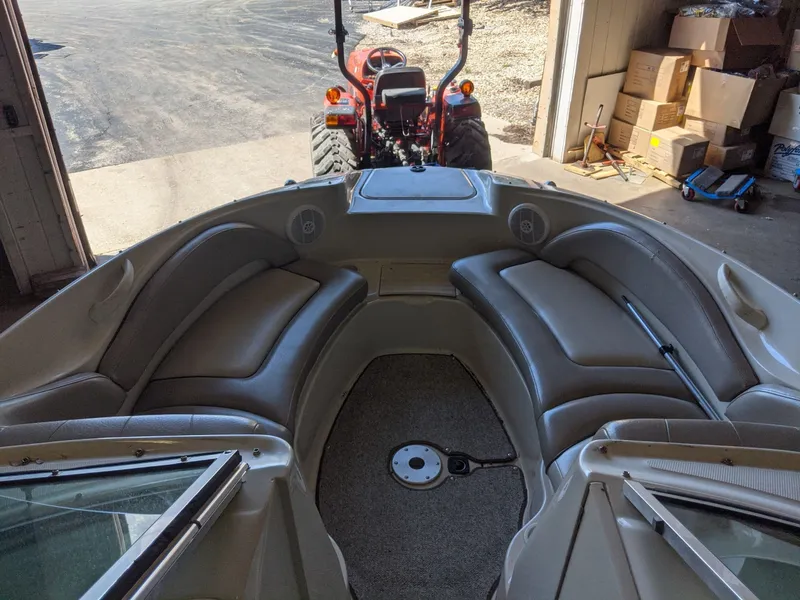 Slide: The Image of Interior view of a Sea Ray 220 Sundeck boat with beige seating and a tractor in the background. - 18