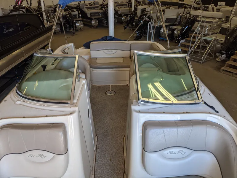 Slide: The Image of Interior view of a Sea Ray 220 Sundeck boat with beige seating and windshields. - 19