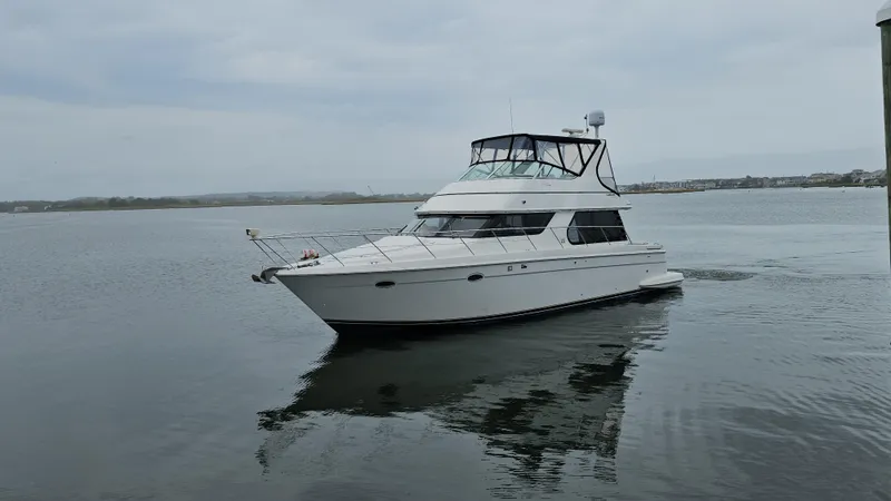 The Image of 2000 Carver 450 Voyager Pilothouse yacht cruising on calm waters. - 0