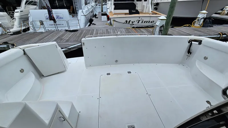 Slide: The Image of 2000 Carver 450 Voyager Pilothouse boat deck at marina, featuring spacious seating area. - 22