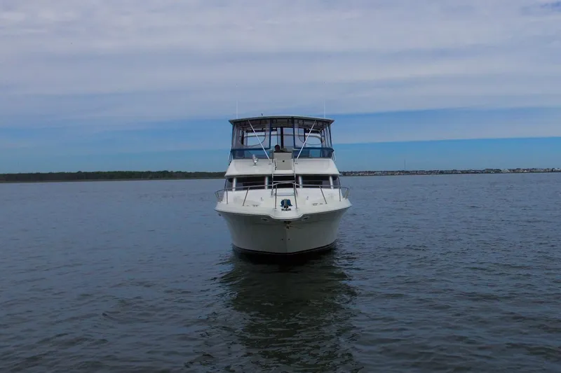 Slide: The Image of Front view of a 1993 Sea Ray 440 Express Bridge yacht on calm water. - 8