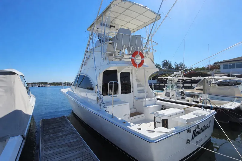 Slide: The Image of 2004 Luhrs 34 Convertible yacht docked at marina under clear blue sky. - 1