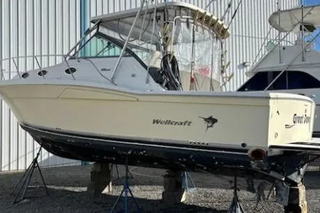 The Image of 2003 Wellcraft 330 Coastal boat on stands, side view, in storage facility. - 0