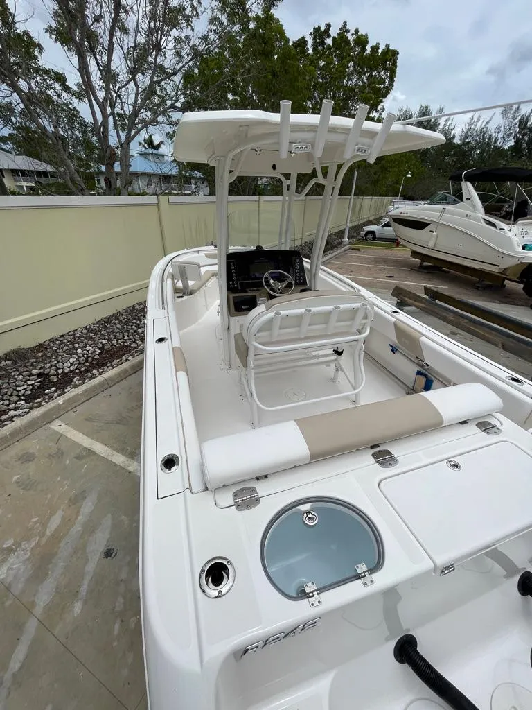 Slide: The Image of 2019 Robalo R242 Center Console boat with T-top and seating, docked outdoors. - 15