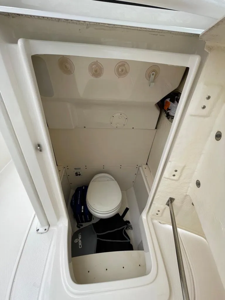 Slide: The Image of 2019 Robalo R242 Center Console boat interior with marine toilet. - 19
