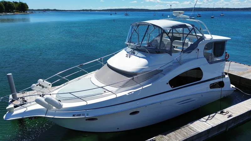 The Image of 2003 Silverton 39 Motor Yacht docked, surrounded by calm water and blue sky. - 0