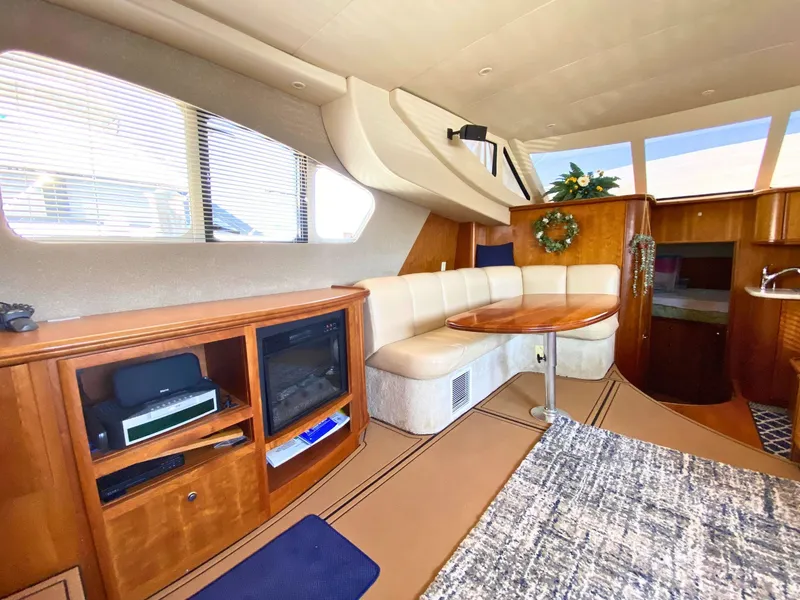 Slide: The Image of Interior of the 2003 Silverton 39 Motor Yacht with cozy seating area and wooden furnishings. - 15