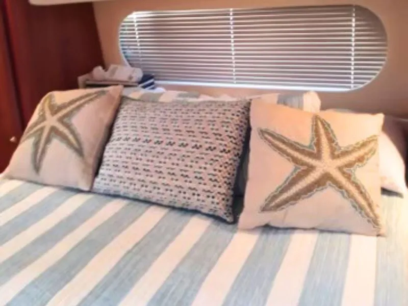 Slide: The Image of Interior of the 2003 Silverton 39 Motor Yacht with striped bedding and starfish pillows. - 24