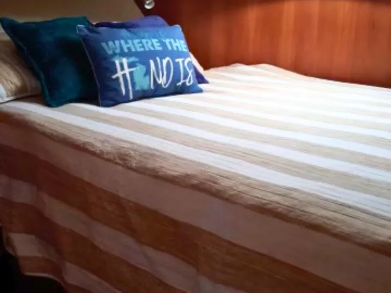 Slide: The Image of Interior of a 2003 Silverton 39 Motor Yacht with a cozy bed and decorative pillows. - 25