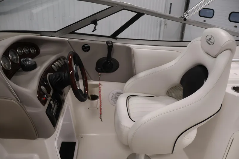 Slide: The Image of 2005 Ebbtide 2300 Sport Cuddy boat interior with steering wheel and white captain's seat. - 14