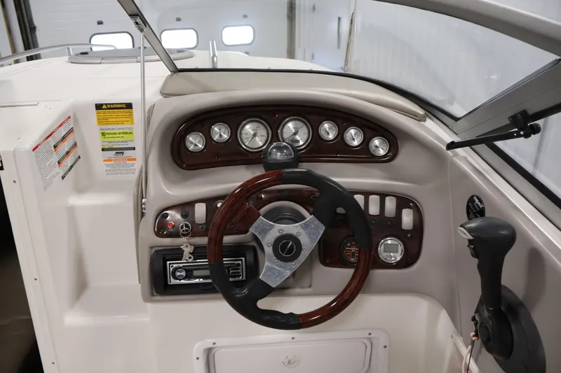 Slide: The Image of 2005 Ebbtide 2300 Sport Cuddy dashboard with steering wheel and instrument panel. - 15