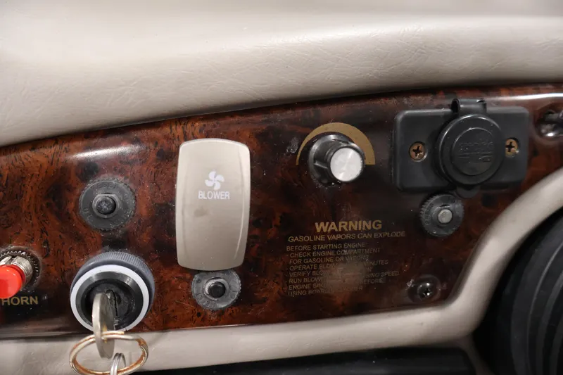 Slide: The Image of Dashboard controls of a 2005 Ebbtide 2300 Sport Cuddy boat, featuring blower switch and warning label. - 19