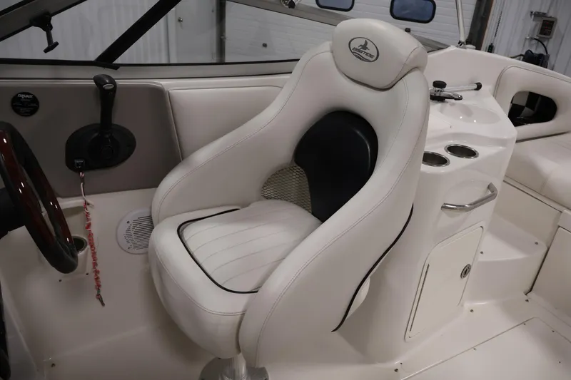 Slide: The Image of 2005 Ebbtide 2300 Sport Cuddy interior with white captain's seat and control panel. - 23