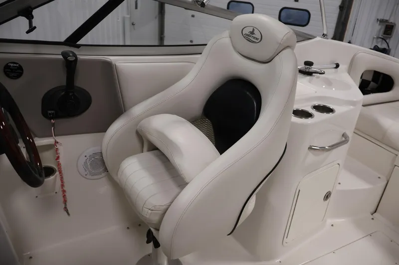 Slide: The Image of 2005 Ebbtide 2300 Sport Cuddy interior with white captain's chair and control panel. - 24