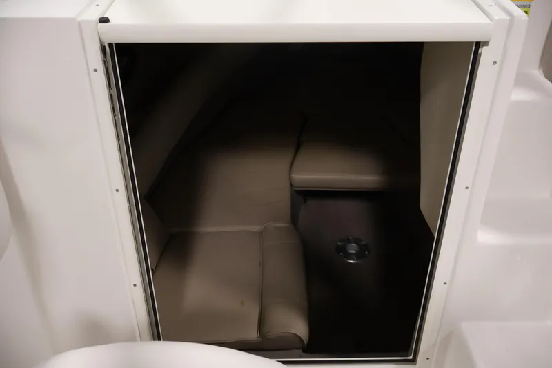 Slide: The Image of 2005 Ebbtide 2300 Sport Cuddy cabin interior with beige seating and compact design. - 27