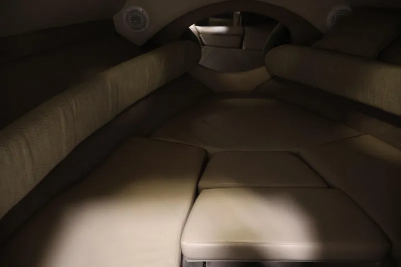 Slide: The Image of 2005 Ebbtide 2300 Sport Cuddy interior with cushioned seating and built-in speakers. - 28