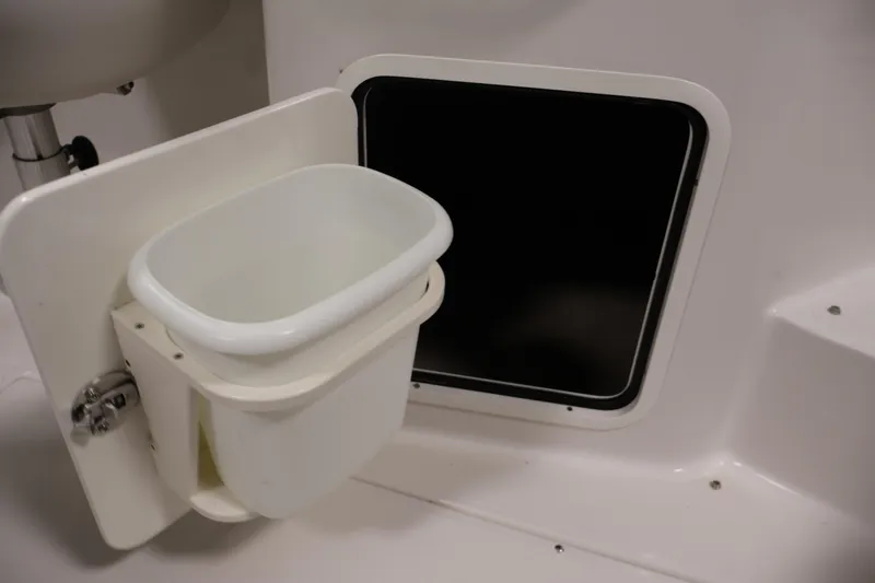 Slide: The Image of Interior of 2005 Ebbtide 2300 Sport Cuddy showing storage compartment and waste bin. - 37