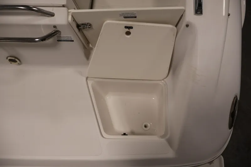 Slide: The Image of 2005 Ebbtide 2300 Sport Cuddy boat storage compartment with open hatch and stainless steel handle. - 39