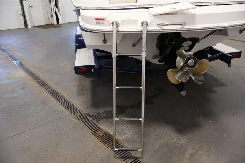 Slide: The Image of Rear view of 2005 Ebbtide 2300 Sport Cuddy with ladder and propeller in garage. - 41