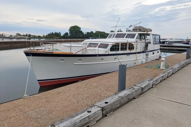 The Image of 1956 Burger Pilothouse yacht docked at a marina, showcasing classic design and elegance. - 0
