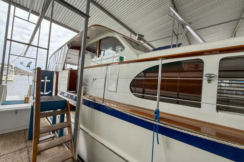 Slide: The Image of 1956 Burger Pilothouse yacht docked in a covered marina, showcasing classic design. - 9