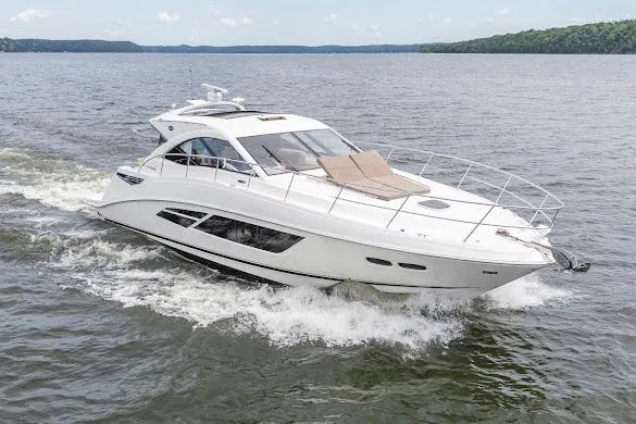 Slide: The Image of 2016 Sea Ray Sundancer 510 cruising on a serene lake with lush green shoreline. - 11
