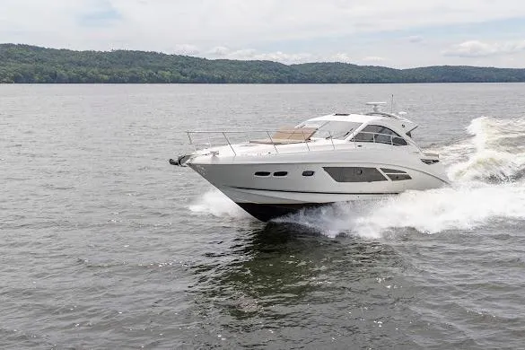Slide: The Image of 2016 Sea Ray Sundancer 510 cruising on a serene lake with lush green hills. - 13