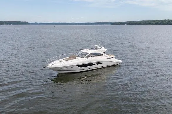 Slide: The Image of 2016 Sea Ray Sundancer 510 yacht cruising on a calm lake under a clear sky. - 14