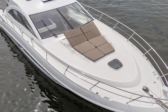 Slide: The Image of 2016 Sea Ray Sundancer 510 yacht on water, featuring sleek design and sunbathing area. - 16