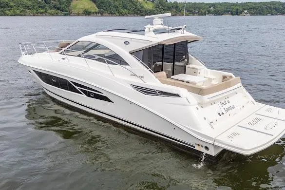Slide: The Image of 2016 Sea Ray Sundancer 510 yacht cruising on a serene lake with lush green shoreline. - 5