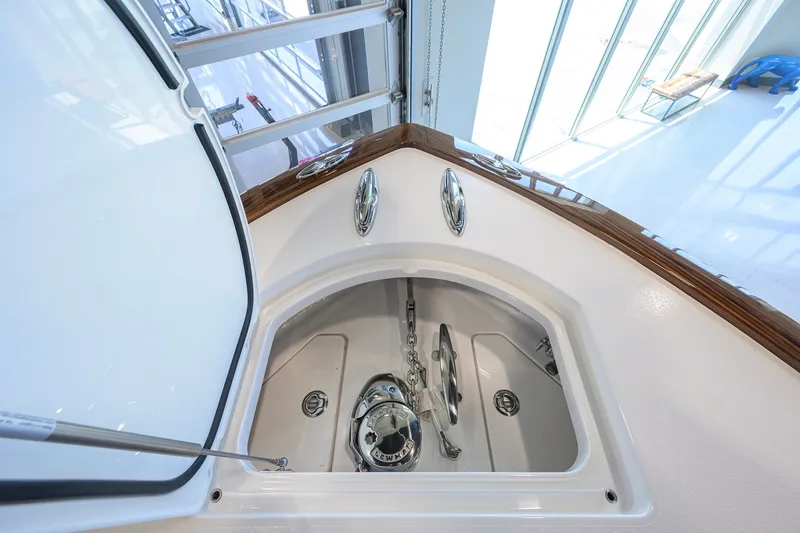 Slide: The Image of 2023 Valhalla Boatworks V-33 anchor compartment with polished hardware and wood trim. - 18