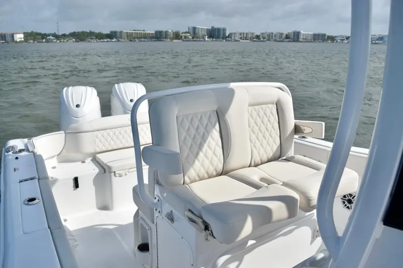 Slide: The Image of 2026 Sea Hunt Ultra 265 SE boat interior with cushioned seating on water. - 11
