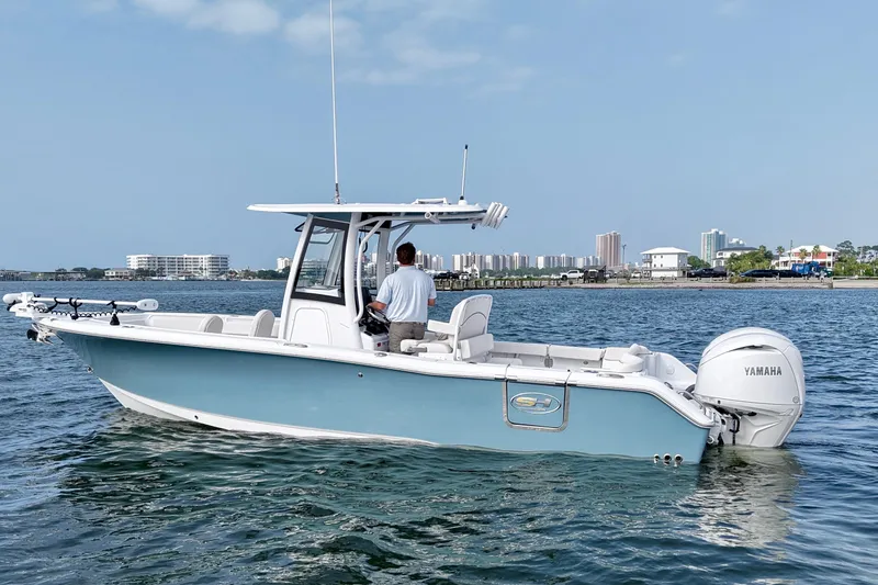 Slide: The Image of 2026 Sea Hunt Ultra 265 SE boat on water, city skyline in background. - 2