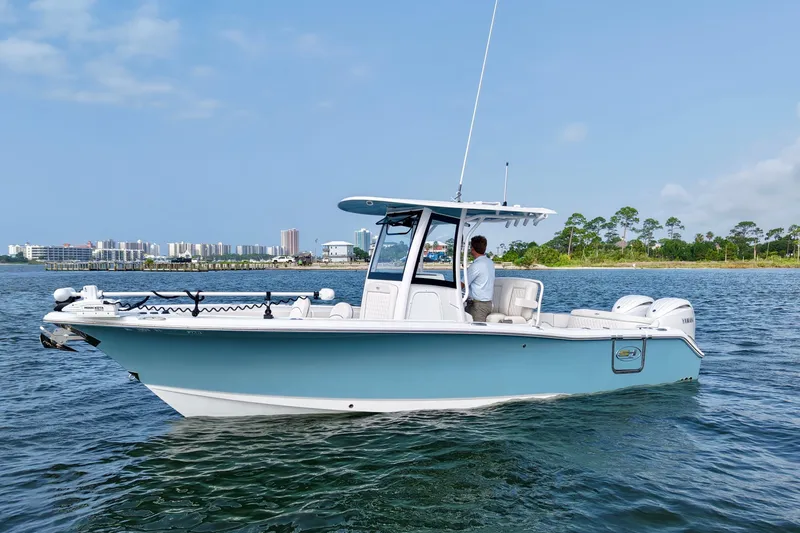 Slide: The Image of 2026 Sea Hunt Ultra 265 SE boat on water, cityscape and trees in background. - 4
