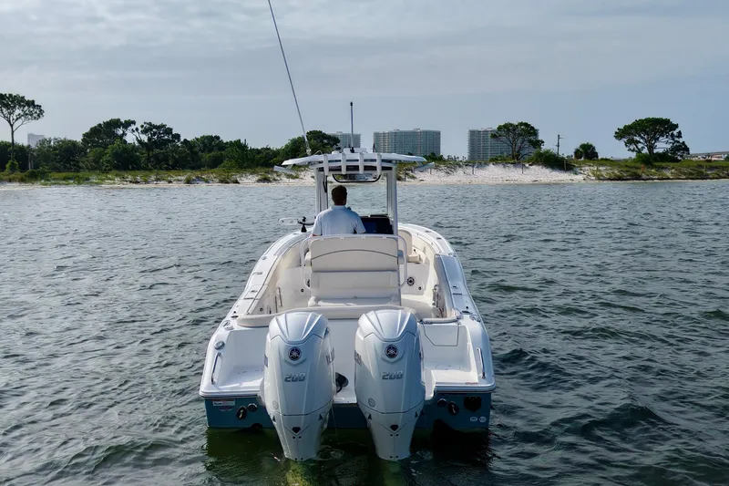 Slide: The Image of 2026 Sea Hunt Ultra 265 SE boat on water near shoreline, featuring dual engines. - 6