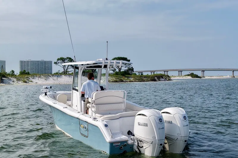 Slide: The Image of 2026 Sea Hunt Ultra 265 SE boat cruising near a coastal bridge. - 8