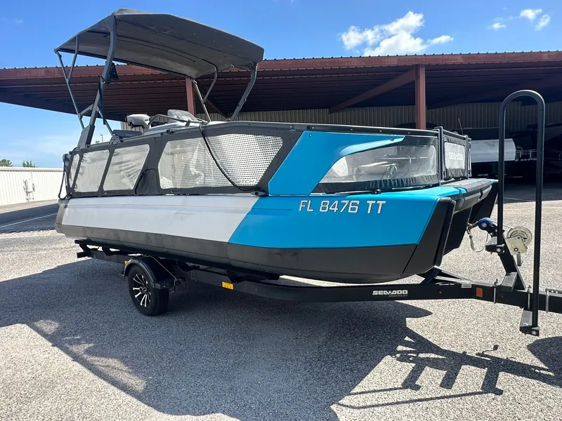 Slide: The Image of A 2023 Sea-Doo 21 SWITCH SPORT on a trailer, featuring a blue and gray hull, under a shelter. - 2