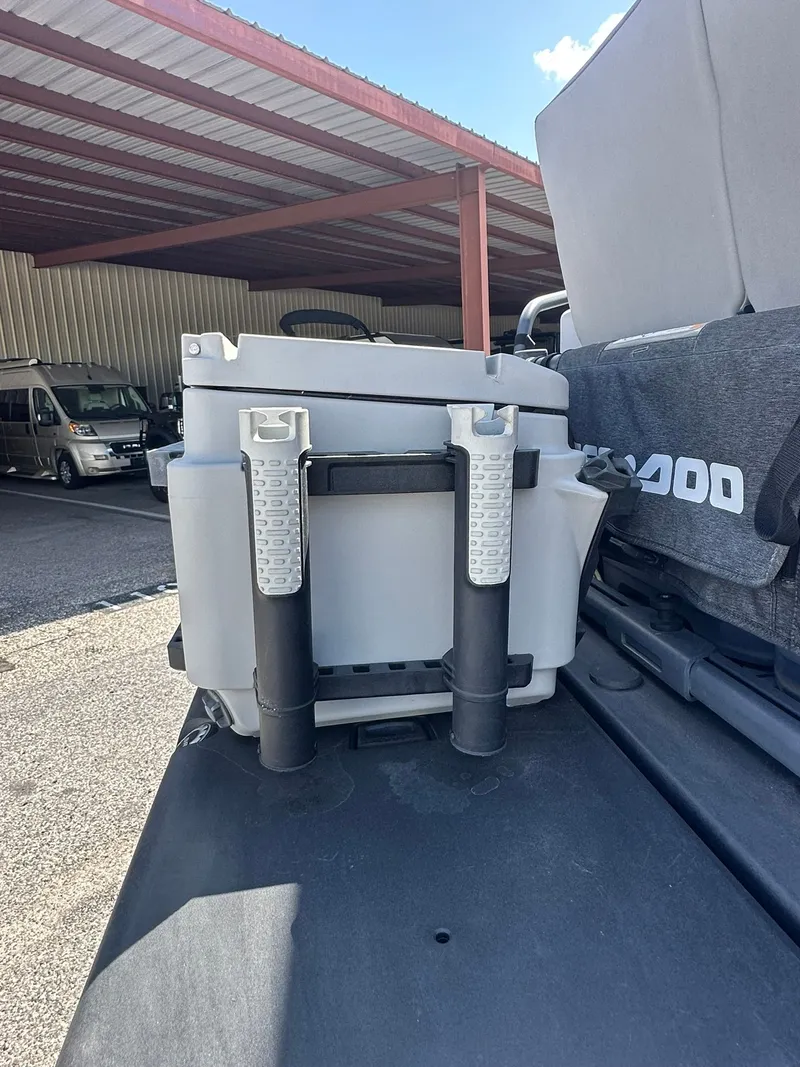 Slide: The Image of A gray cooler on a Sea-Doo boat, parked under a covered area. - 22
