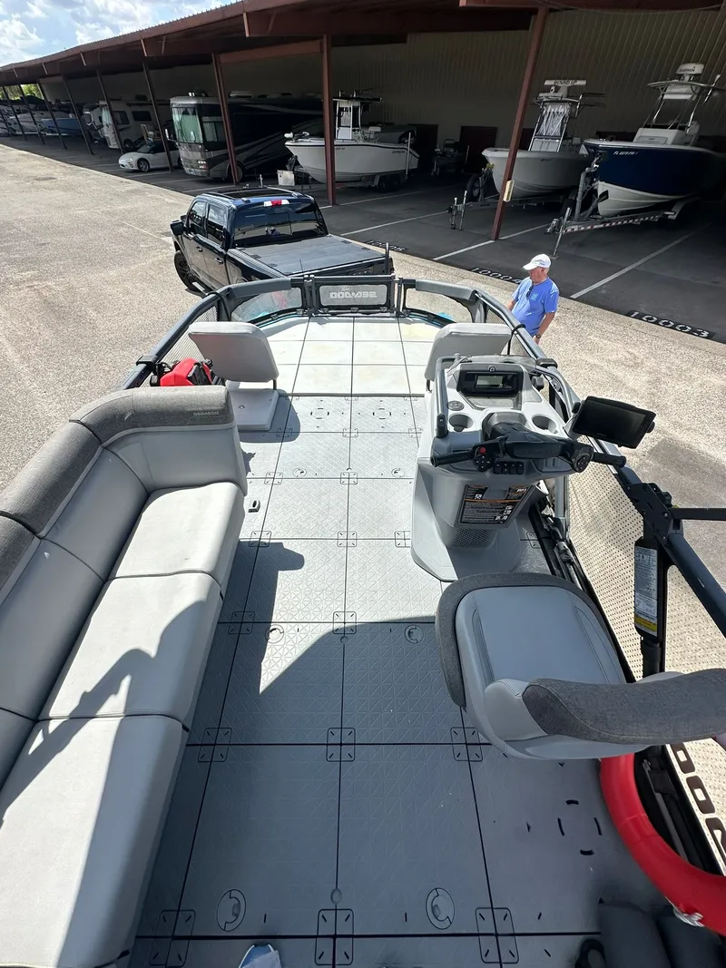 Slide: The Image of The image shows the deck of a 2023 Sea-Doo 21 SWITCH SPORT boat docked in a marina. - 23