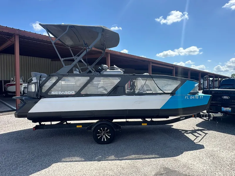 Slide: The Image of A 2023 Sea-Doo 21 SWITCH SPORT boat on a trailer, parked under a covered area. - 4