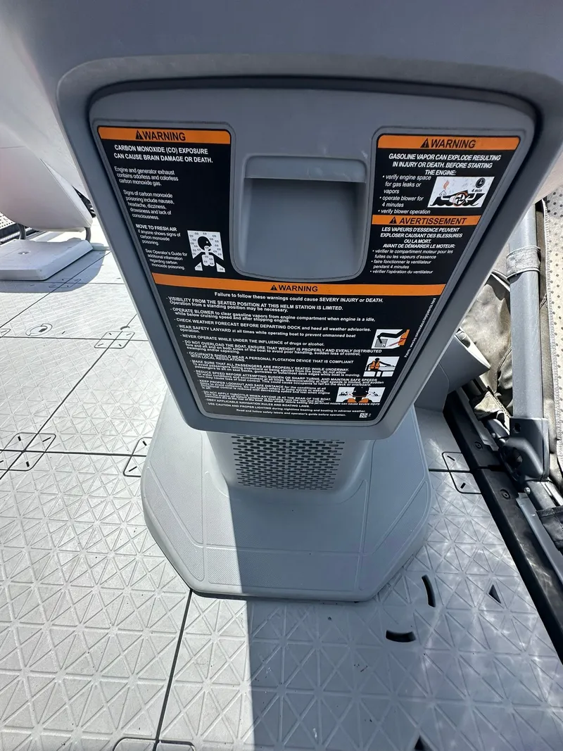Slide: The Image of Close-up of a gray boat part with warning labels. - 48