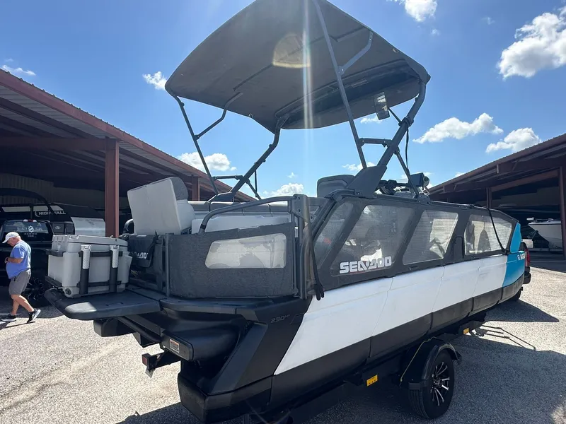 Slide: The Image of A 2023 Sea-Doo 21 SWITCH SPORT with a black canopy sits on a trailer under a covered area. - 6