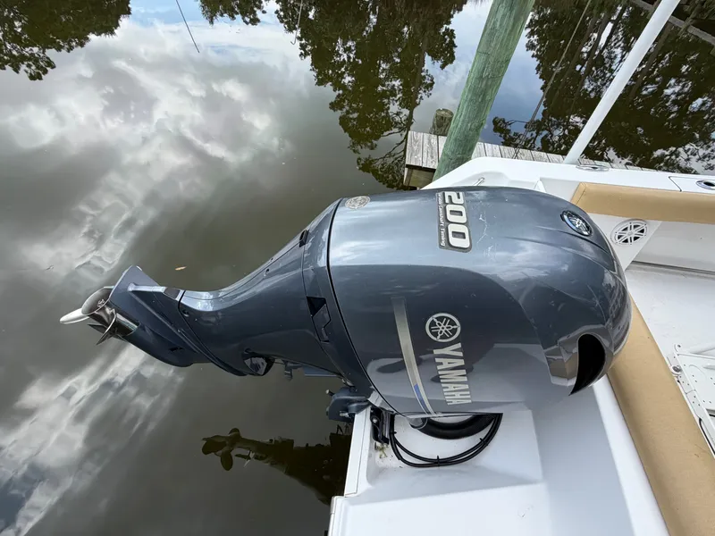Slide: The Image of A Yamaha outboard motor on a boat docked by calm water. - 13