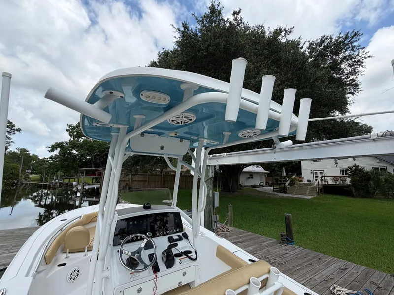 Slide: The Image of 2021 Sportsman Heritage 211 Center Console at dock with blue roof and fishing rod holders. - 19