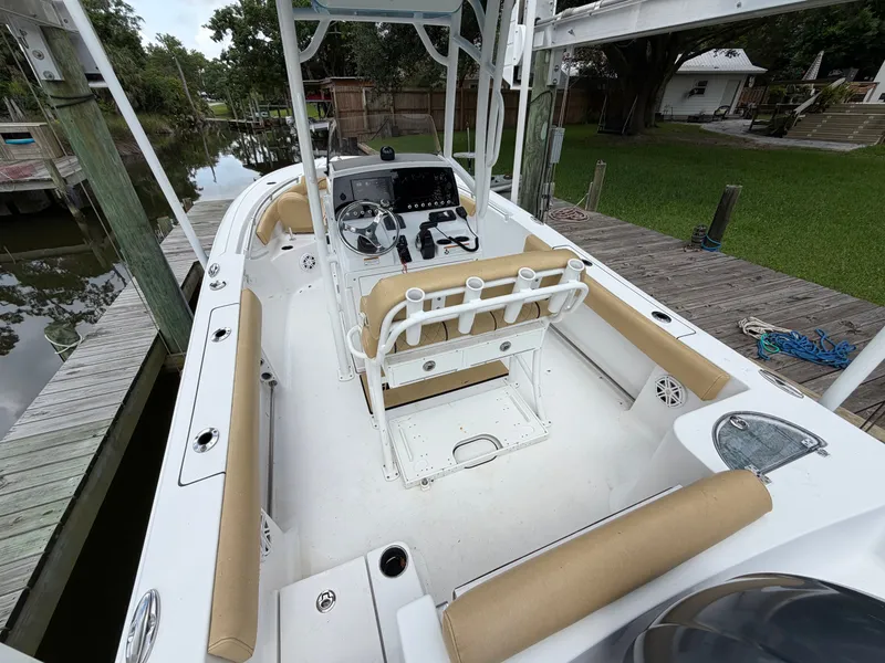 Slide: The Image of 2021 Sportsman Heritage 211 Center Console at dock with beige seating and helm console. - 21
