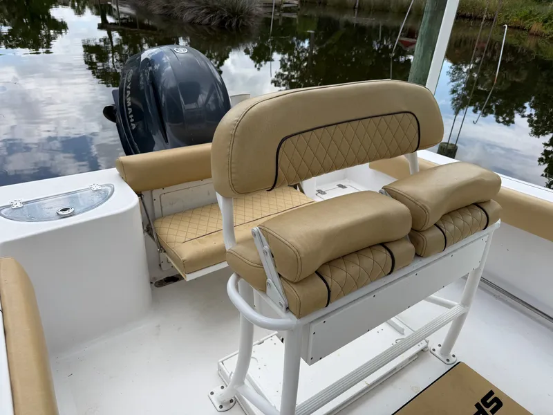 Slide: The Image of The image shows the cockpit of a 2021 Sportsman Heritage 211 Center Console boat with beige upholstery. - 28