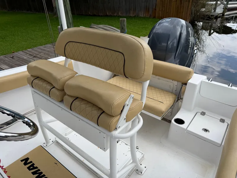 Slide: The Image of The image shows the cockpit of a Sportsman Heritage 211 Center Console boat with beige seats. - 32