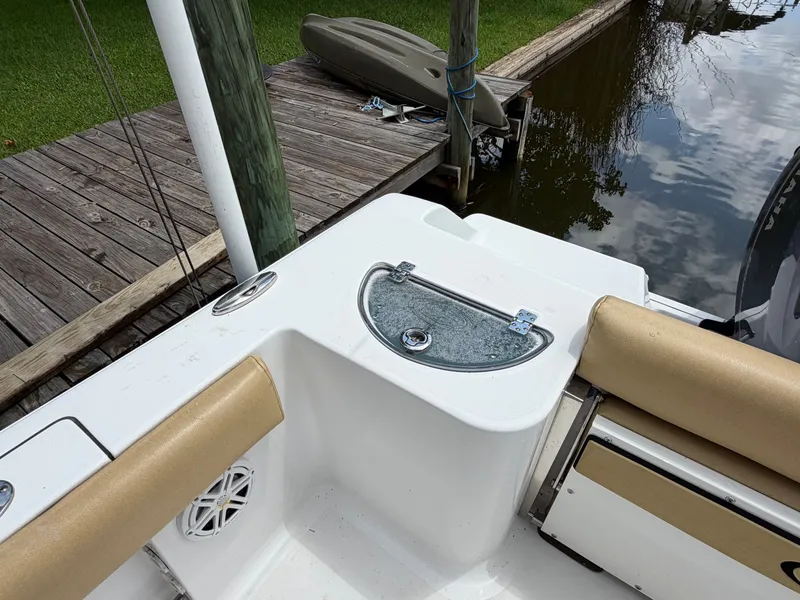 Slide: The Image of A 2021 Sportsman Heritage 211 Center Console is docked by a wooden pier. A kayak is visible in the background. - 34