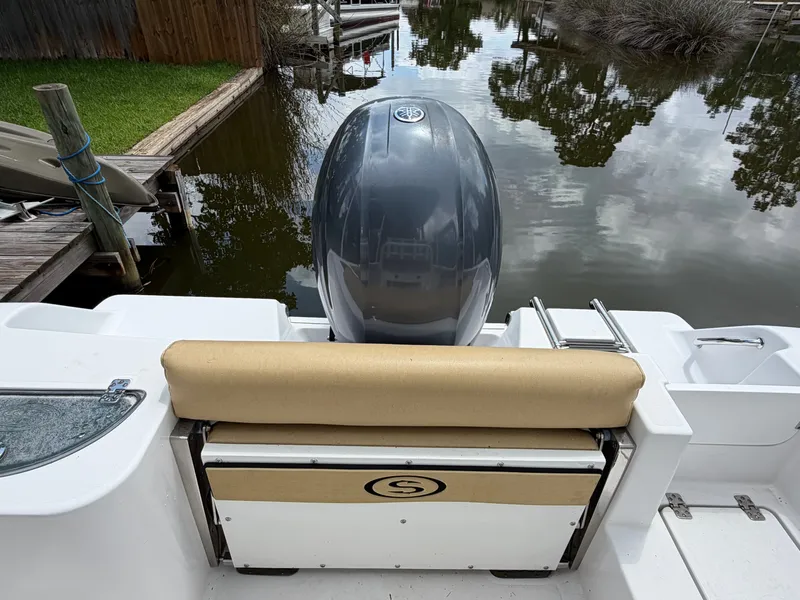 Slide: The Image of Rear view of a Sportsman Heritage 211 with outboard motor at a calm dock. - 36